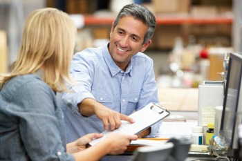 Business Colleagues Working At Desk In Warehouse